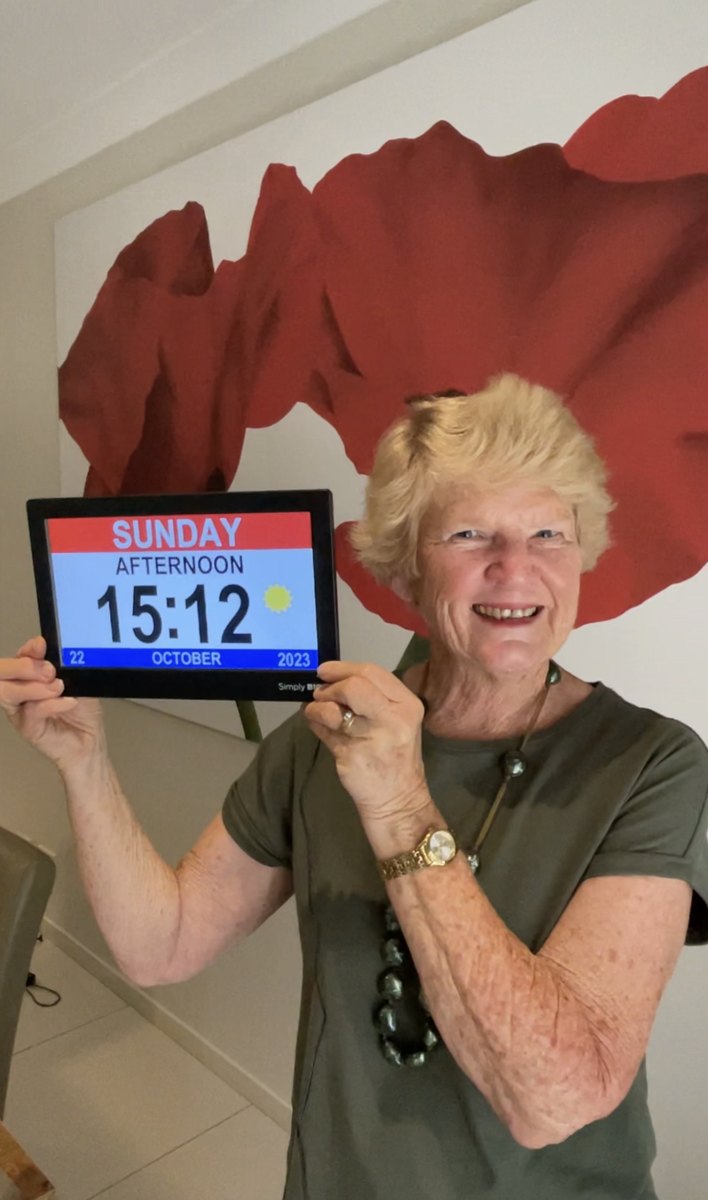 Woman at home holding up the clock